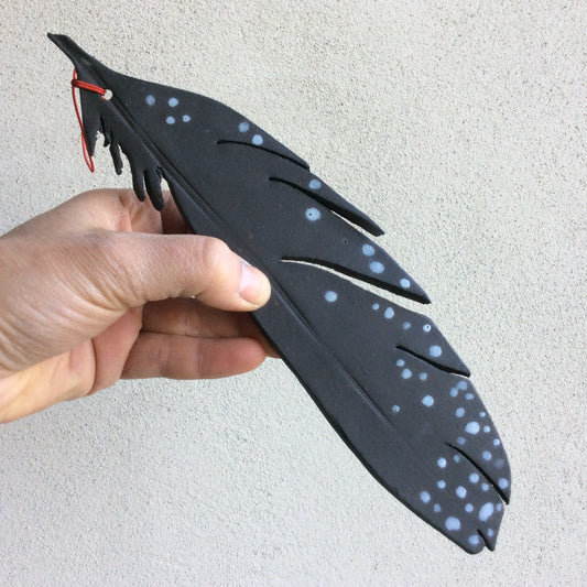 Black feather with white dots
